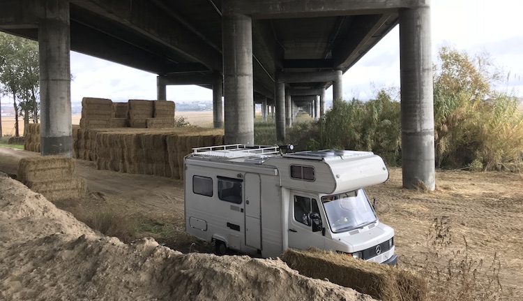 Van parked under a highway bridge