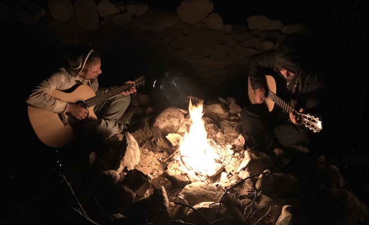 Playing guitar at a camp fire