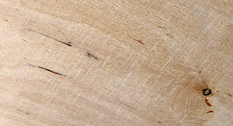 Raw wooden panels with vertical scratches