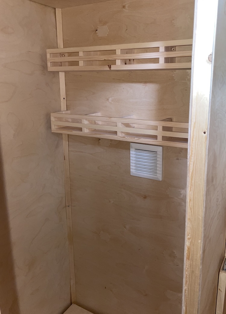 Shelves mounted into the bathroom above the toilet