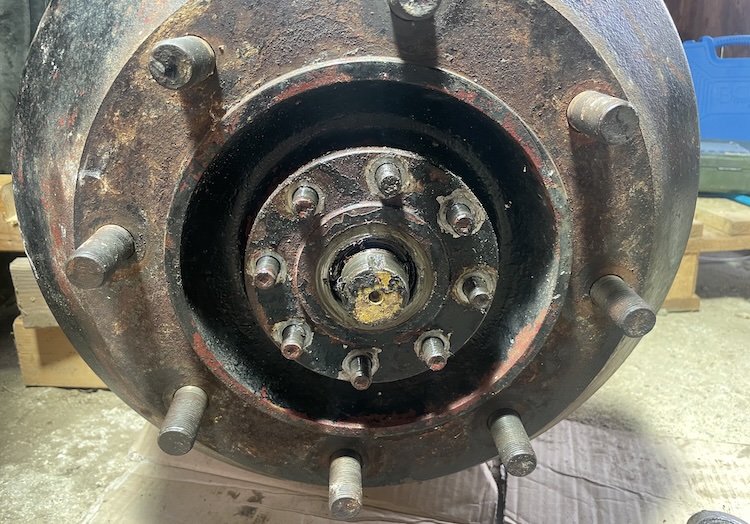 Removing the eight nuts that press the drive flange onto the brake drum