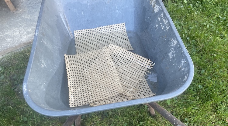 Soaking the Vienna straw matting in warm water before installation