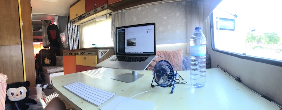 Laptop on a stand with an external keyboard and trackpad in the back of my van